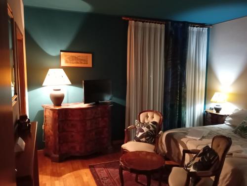 a bedroom with a bed and a tv and a chair at 49 Le Contesse Ide in Meolo