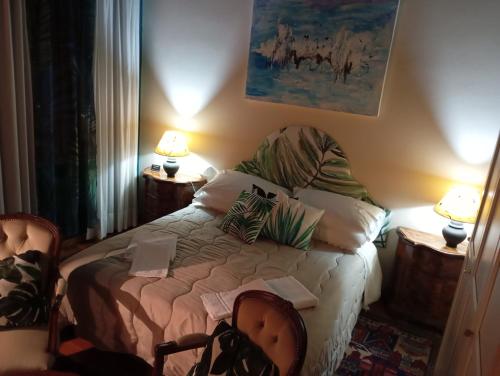 a bedroom with a bed with two lamps and two chairs at 49 Le Contesse Ide in Meolo