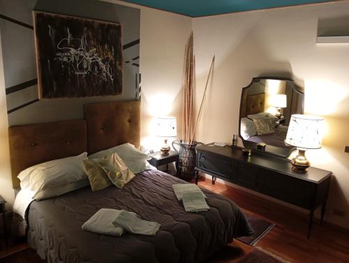 a bedroom with a bed with a dresser and a mirror at 49 Le Contesse Ide in Meolo