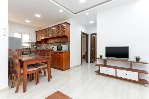 a kitchen and dining room with a table and a tv at Lazur Sea & City Apartment's - El Hadaba, Hurghada - Egypt in Hurghada