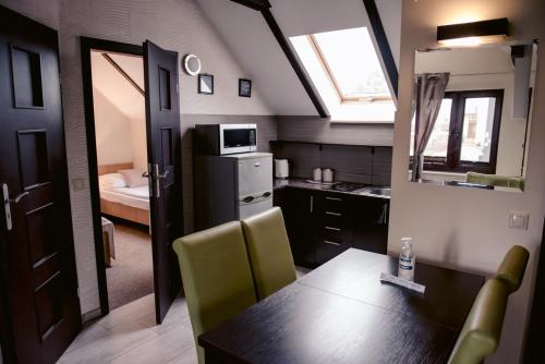 a kitchen with a dining table and a room with a bed at Apartamenty Riffe 99 m od najpiękniejszej plaży w Polsce in Rewa