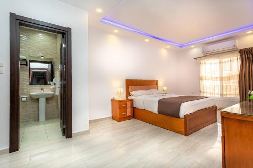 a bedroom with a bed and a bathroom with a sink at Lazur Sea & City Apartment's - El Hadaba, Hurghada - Egypt in Hurghada