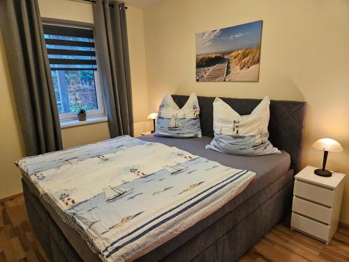 a bedroom with a bed with pillows and a window at Ferienwohnung Ostsee und Strand in Ribnitz-Damgarten