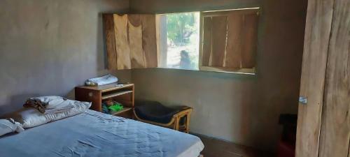 a bedroom with a bed and a window at Cabañas Casa de Agua in Boca del cielo