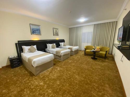 a hotel room with two beds and a couch at Bab Al Multazam Concorde Hotel in Makkah