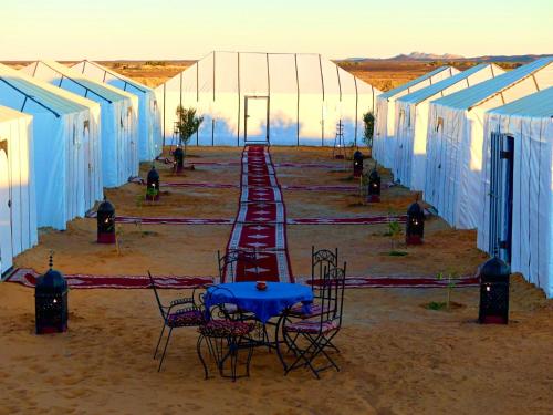 a row of tables and chairs in a tent at Rainbow Desert Camp in Merzouga