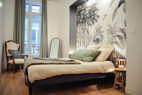 Schlafzimmer mit einem Bett und einem Wandbild von Palmen in der Unterkunft La perle de la République - Au coeur du centre historique in Montauban