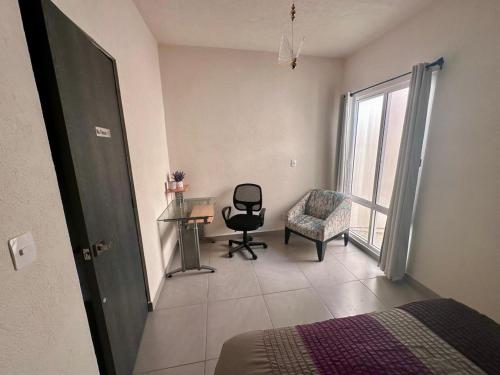ベラクルスにあるPorteño Abodeのベッドルーム1室(ベッド1台、椅子、窓付)