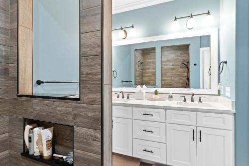 a bathroom with a white sink and a mirror at All the Views Ocean Isle Beach, heated private pool, close to beach in Ocean Isle Beach