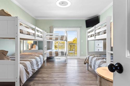 a room with three bunk beds and a table at All the Views Ocean Isle Beach, heated private pool, close to beach in Ocean Isle Beach