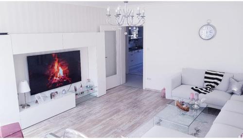 a white living room with a fire in the fireplace at Hannover City Suite in Hannover