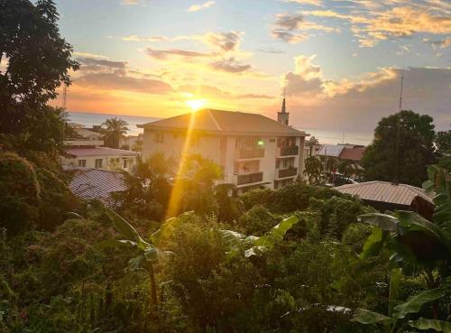 a building with the sun setting in the background at Case Louis et spa in Saint-Pierre