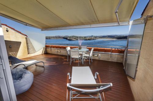 - Balcón con mesa y sillas en un barco en Apartamento Faro de Suances, en Suances