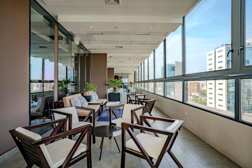 an office with chairs and tables and windows at Hampton By Hilton Santiago Las Condes in Santiago