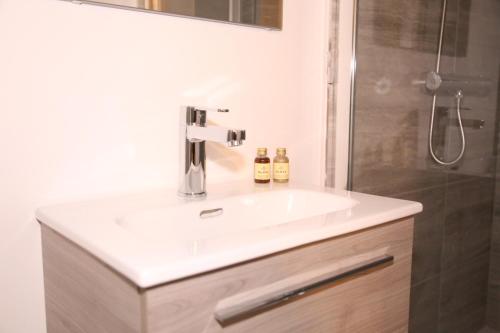 y baño con lavabo blanco y ducha. en Star London Golders Rise Luxury 4-Bed Oasis with Garden en Hendon