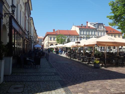 une rue vide avec des tables, des chaises et des parasols dans l'établissement MAXX, à Bielsko-Biała