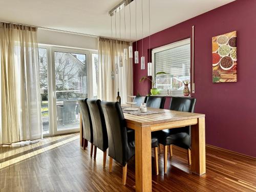 uma sala de jantar com uma mesa de madeira e cadeiras pretas em Schönes Familienhaus mit Herz im Grünen (Tübingen) em Kusterdingen