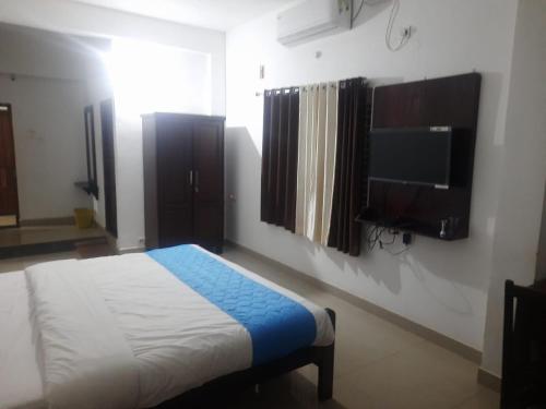 sypialnia z łóżkiem i telewizorem z płaskim ekranem w obiekcie Hotel Mother Palace - Blue Rays w mieście Baindūru