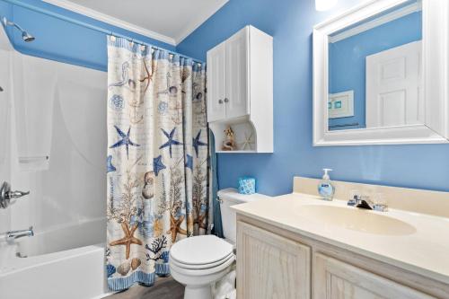 een badkamer met een wastafel en een douchegordijn bij Beach D-ehs Brunswick Vacation Rentals in Ocean Isle Beach