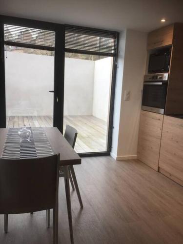 une salle à manger avec une table et une cuisine dans l'établissement TRESTRIGNEL MAGNIFIQUE VUE MER. Studio à PERROS-GU, à Perros-Guirec