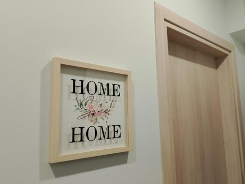 a home home sign on a wall next to a door at Black Eagle Apartment in Drama