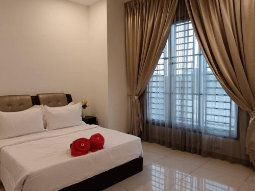 dos rosas rojas sentadas en una cama en un dormitorio en DESARU SERENITA Homestay NETFLIX WIFI, en Bandar Penawar