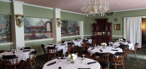 a dining room with tables and chairs and a chandelier at Historical Hotel - House of Ludington in Escanaba