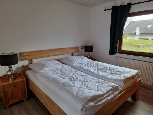 Bett in einem Zimmer mit einem Fenster und einem Bett sidx sidx sidx sidx in der Unterkunft Ferienhaus im Seepark von Kirchheim in Kirchheim