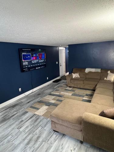 a living room with two couches and a flat screen tv at Entire level just off Interstate, free breakfast in Fargo