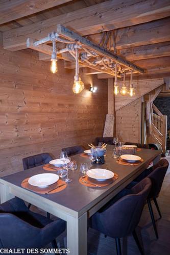 une table à manger avec des chaises et une longue table avec des verres dans l'établissement Le Chalet des Sommets à Briançon, à Puy-Saint-Pierre
