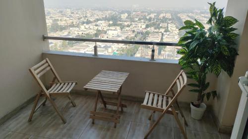 Duas cadeiras e uma mesa numa varanda com vista em Fun Bedroom Apartment in Gold Crest Mall and Residency DHA Lahore em Lahore