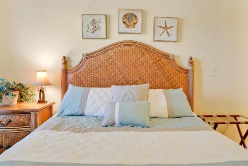 a bed with a wooden headboard and pillows on it at Ain`t It The Life Brunswick Vacation Rentals in Ocean Isle Beach