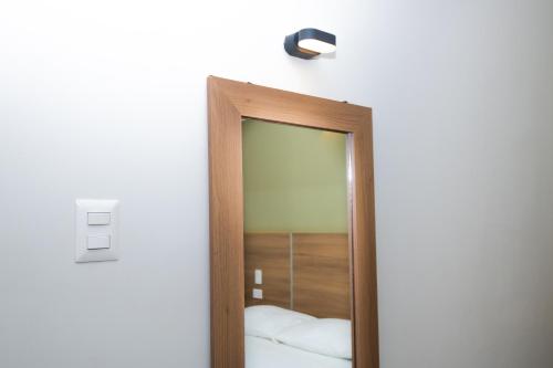 einen Spiegel in einem Zimmer mit Licht an der Wand in der Unterkunft Zentra Hotel in Chiclayo