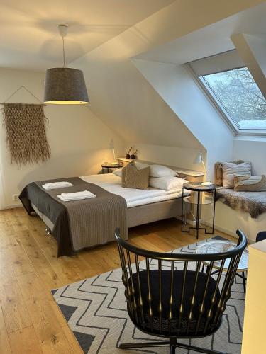 une chambre mansardée avec un lit et une fenêtre dans l'établissement Halmstad Gårdshotell, à Halmstad