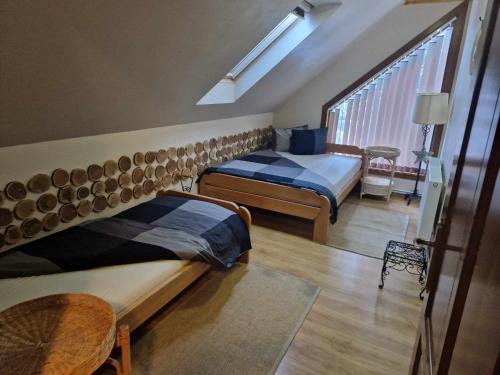 una camera da letto con due letti, un tavolo e una finestra di Paltán Vendégház a Borzont