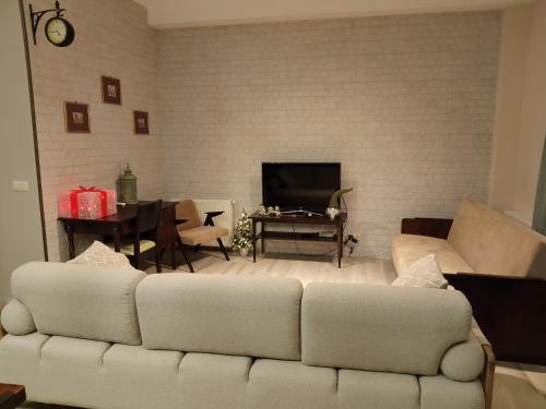 a living room with a white couch and a table at Medea's Home in Kutaisi