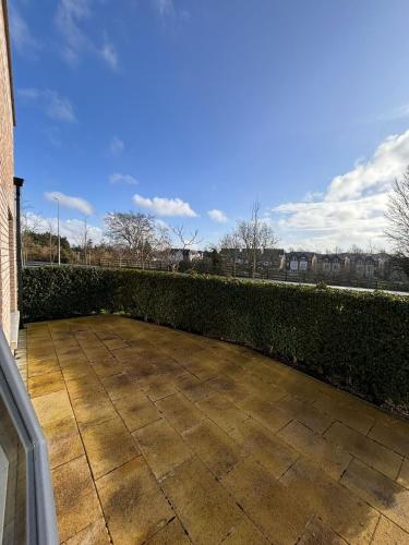 a patio with a hedge in front of a building at Maynooth Private Room in a 2 bedroom shared house in Maynooth