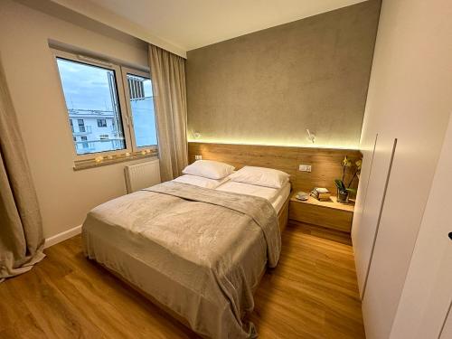 sypialnia z dużym łóżkiem i oknem w obiekcie Bagry Apartments w Krakowie