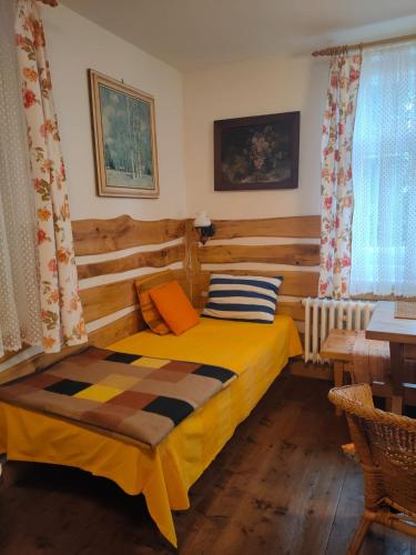 a bedroom with a bed and a table and a window at U Mushera in Vrchlabí