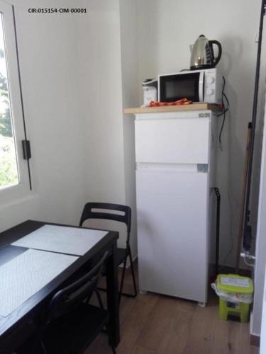 uma pequena cozinha com um micro-ondas em cima de um frigorífico em Camere La villetta vicino rho fiera e Malpensa em Nerviano