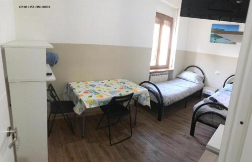 Cette petite chambre comprend une table et un lit. dans l'établissement Camere La villetta vicino rho fiera e Malpensa, à Nerviano