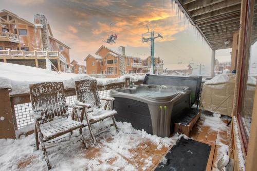 a snow covered balcony with two chairs and a sink at Southwinds Ultimate Slope Side Relaxation Spot in Champion