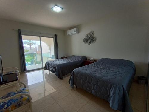 een slaapkamer met 2 bedden en een balkon bij FINCA LUZ DEL MAR in Topolobampo