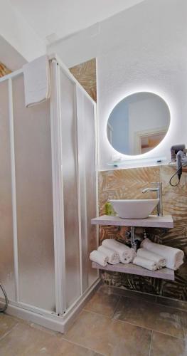 a bathroom with a sink and a mirror and towels at THE SUN HOTEL BOUTIQUE NAPOLI in Naples