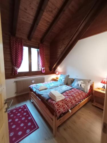 ein Schlafzimmer mit einem großen Bett im Dachgeschoss in der Unterkunft La casa dello stambecco in Tarvis