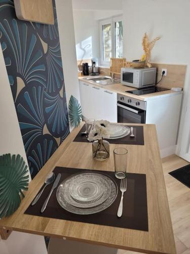 une cuisine avec une table en bois et une plaque de cuisson. dans l'établissement Le petit Bédier, à Angers