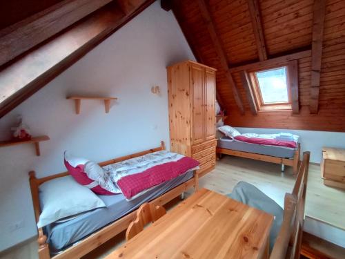 ein Schlafzimmer mit 2 Betten und einem Tisch in einer Hütte in der Unterkunft La casa dello stambecco in Tarvis