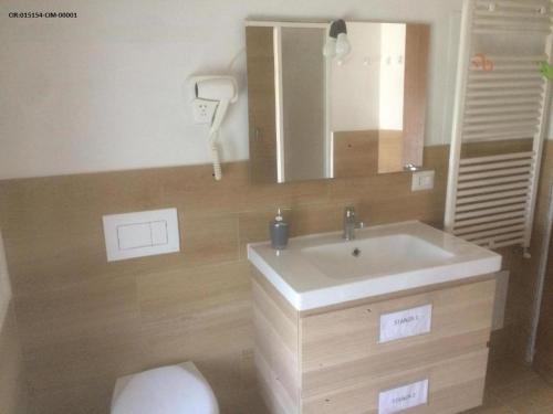 bagno con lavandino, servizi igienici e specchio di Appartamento trilocale la villetta a Parabiago