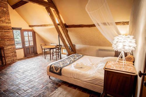 a bedroom with a bed and a table and chairs at Domaine à la campagne- 16 couchages in Vallery