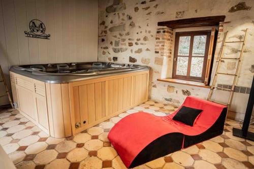 a kitchen with a stove and a red chair at Domaine à la campagne- 16 couchages in Vallery